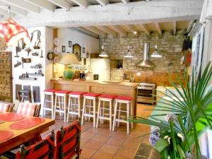 eine Küche mit roten Barhockern in einem Zimmer in der Unterkunft Villa de 8 chambres avec piscine privee jardin amenage et wifi a Haut de Bosdarros in Haut-de-Bosdarros