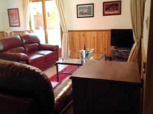 a living room with a leather couch and a coffee table at Maison de 2 chambres avec vue sur le lac piscine partagee et jardin amenage a Lachapelle Auzac in Lachapelle-Auzac