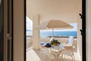 トラッペートにある3 bedrooms apartement at Piano di Trappeto 1 m away from the beach with sea view furnished terrace and wifiのテーブル(傘付)、デスク(ノートパソコン付)