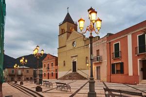 una luz de la calle frente a un edificio con una torre de reloj en One bedroom appartement with city view and wifi at Teulada 5 km away from the beach, en Teulada