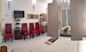 a living room with red chairs and a bedroom at Spacious Apartment in Realmonte, Sea View in Realmonte
