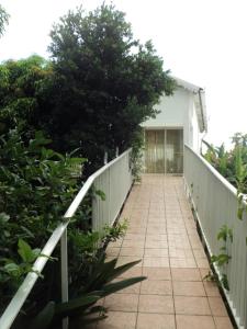 una pasarela que conduce a una casa con una valla en Appartement de 2 chambres avec vue sur la mer piscine partagee et jardin clos a Bois des Nefles Saint Paul, en Le Bois de Nèfles