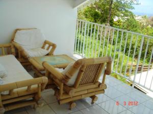 balcón con mesa y sillas en Appartement de 2 chambres avec vue sur la mer piscine partagee et jardin clos a Bois des Nefles Saint Paul, en Le Bois de Nèfles