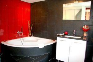 a red bathroom with a tub and a sink at Charming House in Santa Eulalia, perfect for 18 guests in Santa Eulália +13 photos