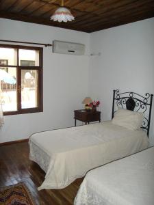 1 dormitorio con 2 camas y ventana en Begonville Villa, en Koycegiz