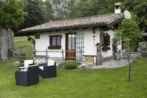 a small white house with a grass yard at Baita Tana da l'Ors in Forgaria nel Friuli
