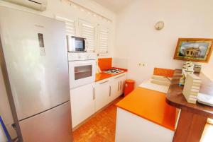 een keuken met een witte koelkast en een aanrecht bij Bungalow de 2 chambres a Le Diamant a 50 m de la plage avec vue sur la mer jardin clos et wifi in Le Diamant