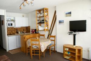 a small kitchen with a table and a television at Studio a Montgenevre a 400 m des pistes avec balcon et wifi in Montgenèvre