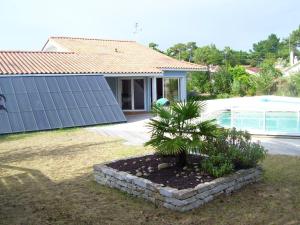 サンティレール・ド・リエにあるVilla de 3 chambres avec piscine privee et jardin clos a Saint Hilaire de Riez a 1 km de la plageの庭の小さなヤシの木がある家