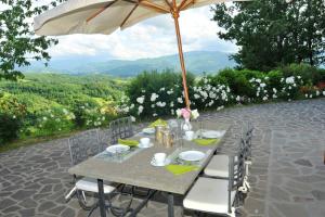 - une table avec un parasol sur la terrasse dans l'établissement 2 bedrooms house with shared pool enclosed garden and wifi at Gattaia, à Gattaia