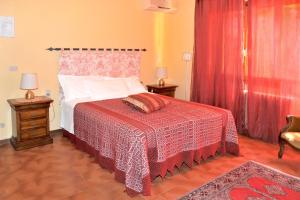 a bedroom with a bed with a red and white bedspread at 2 bedrooms house with shared pool enclosed garden and wifi at Gattaia in Gattaia