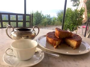 a plate with a piece of cake and a cup of coffee at 2 bedrooms house with shared pool enclosed garden and wifi at Gattaia in Gattaia