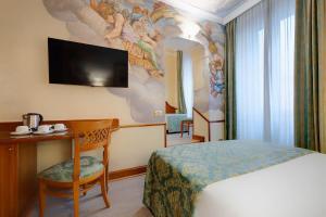 a hotel room with a bed and a flat screen tv at Hotel Amalfi in Rome
