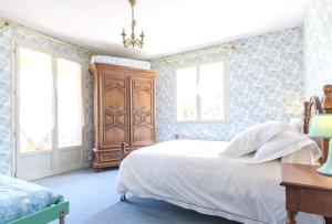 フォワにあるVilla de 4 chambres avec vue sur la ville piscine privee et jacuzzi a Foixのベッドルーム1室(ベッド1台付)、木製キャビネットが備わります。