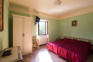 a bedroom with a red bed and a window at 3 bedrooms house with furnished terrace and wifi at Castelnuovo di Garfagnana in Castelnuovo di Garfagnana