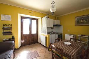 un soggiorno con tavolo e cucina di 3 bedrooms house with furnished terrace and wifi at Castelnuovo di Garfagnana a Castelnuovo di Garfagnana