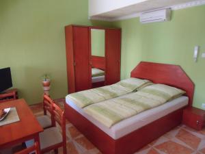 A bed or beds in a room at Nefelejcs Apartman