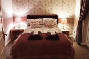 a bedroom with a large bed with two lamps at The Wee Studio For Two in Stirling