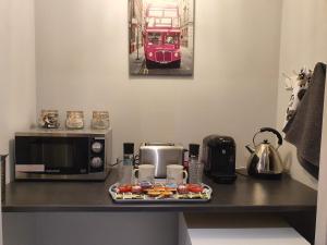 a counter with a microwave and a plate of food at The Wee Studio For Two in Stirling