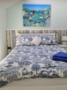 a bedroom with a bed with a blue and white bedspread at Captivating Isolde Cottage with pool near St Ives in Camborne