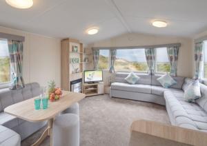 a living room with a couch and a table at Stunning 6 Birth Caravan in Skegness Herons Mead in Orby