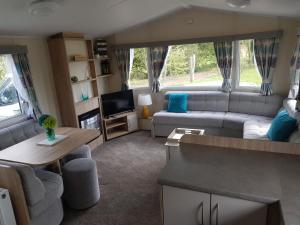 a caravan living room with a couch and a table at Stunning 6 Birth Caravan in Skegness Herons Mead in Orby