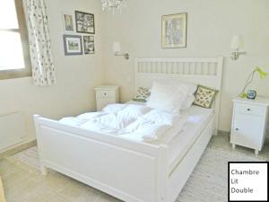 a large white bed in a bedroom with a window at Chalet de 3 chambres a Peisey Nancroix a 500 m des pistes avec terrasse et wifi in Peisey-Nancroix