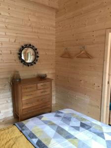 a bedroom with a bed and a wooden wall at Off Grid Hideaway on the West Coast of Scotland in Blairmore