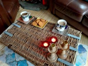 a coffee table with two cups of coffee and cookies at Off Grid Hideaway on the West Coast of Scotland in Blairmore