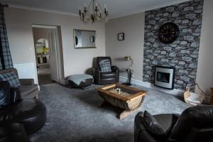 - un salon avec des canapés et une cheminée en pierre dans l'établissement The View 3-Bed Cottage Findochty Buckie Moray, à Findochty