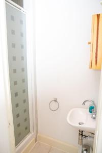 a white bathroom with a sink and a shower at Sandgate 2-Bed Apartment in Ayr central location in Ayr