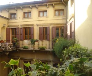 a building with a balcony with potted plants on it at Protezione della Giovane - female hostel in Verona