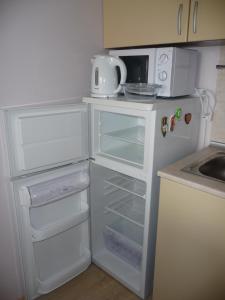 una cocina con una nevera blanca con la puerta abierta en Great Choice Apartment, en Chernomorets