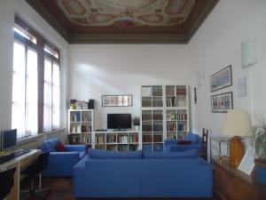 a living room with blue couches and a tv at Protezione della Giovane - female hostel in Verona