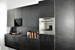 a kitchen with black cabinets and an oven at 1-Bed Apartment in Zabrze 15 min Katowice Gliwice in Zabrze