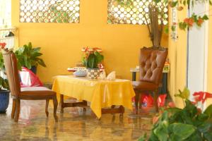a yellow room with a table and two chairs at Villa élégante à Sainte-Anne avec piscine privée ouverte toute l'année in Sainte-Anne