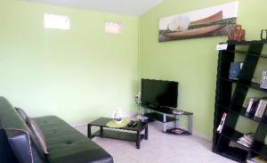 sala de estar con sofá y TV en Maison de 2 chambres avec jardin clos et wifi a Riviere Salee a 8 km de la plage, en Rivière-Salée