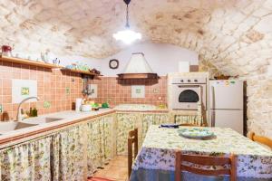 a kitchen with a table and a white refrigerator at Comfortable Apartment in Modica, 80 m² + Terrace in Modica