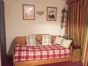 una cama con un osito de peluche sentado encima en Studio avec balcon amenage a Valloire a 1 km des pistes, en Valloire