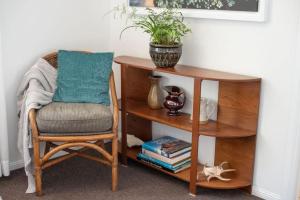 a chair next to a wooden table with a plant on it at Bohemia Heights in Westcourt