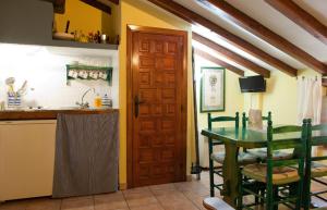 a kitchen with a table and a sink and a door at Comfortable Apartment in Robledillo de Gata with Balcony and View in Robledillo de Gata