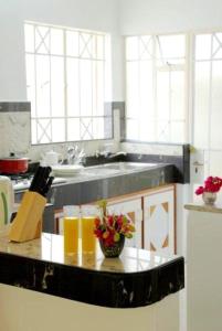 a kitchen with a counter with two glasses of orange juice at Spacious House in Flic en Flac with Shared Pool in Flic-en-Flac