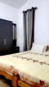 a bedroom with a bed and a window with curtains at Spacious House in Flic en Flac with Shared Pool in Flic-en-Flac