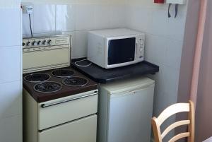 um micro-ondas sentado em cima de um fogão numa cozinha em 4 berth first floor flat Glen Villa 3 em Great Yarmouth