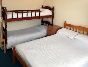 2 camas individuais num quarto com 2 beliches em 4 berth first floor flat Glen Villa 3 em Great Yarmouth