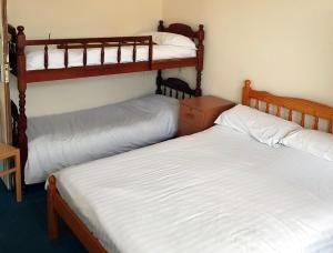 two twin beds in a room with two bunk beds at 4 berth first floor flat Glen Villa 3 in Great Yarmouth