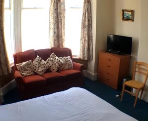 uma sala de estar com um sofá e uma televisão em 4 berth first floor flat Glen Villa 3 em Great Yarmouth