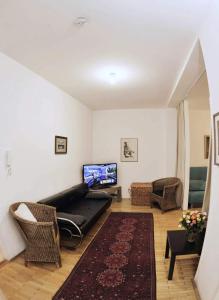 Apartmán Old centre - Rybárska brána في براتيسلافا: غرفة معيشة مع أريكة وكراسي وتلفزيون