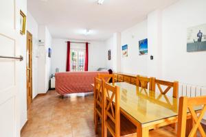 a dining room with a table and chairs and a bedroom at Inviting house in Lepe with shared pool. in Lepe