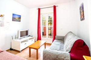 a living room with a couch and a tv at Inviting house in Lepe with shared pool. in Lepe